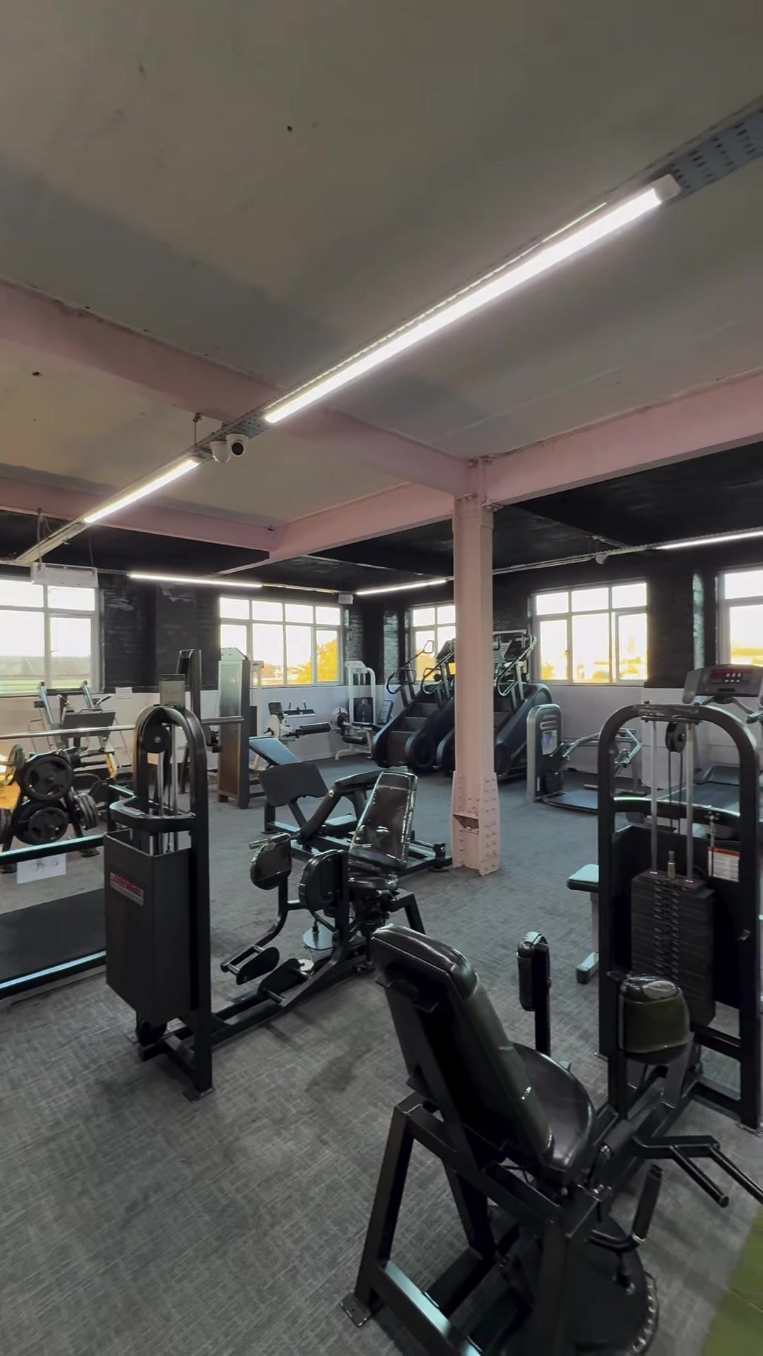 The gym floor with machines under the pink ceiling