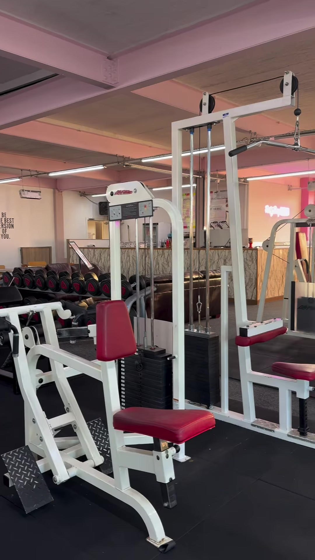 White resistance machines lined up on the gym floor